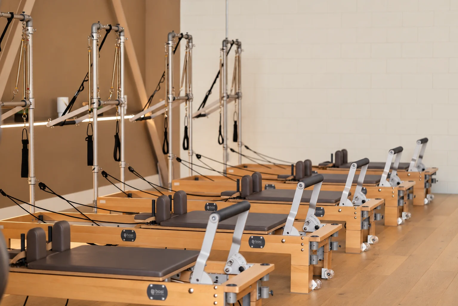 Wooden BASI Reformers and Towers ready for a small-group class at Titan