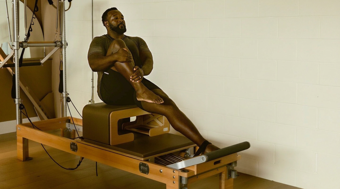 A client stretching on a Reformer at Titan Pilates